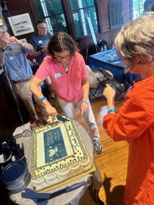 Photo of W-L alumni at 75th anniversary cutting cake.